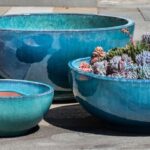 Three blue pottery planters, one holding succlents
