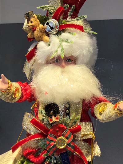 A Mark Roberts Santa doll collectible wearing different Christmas items