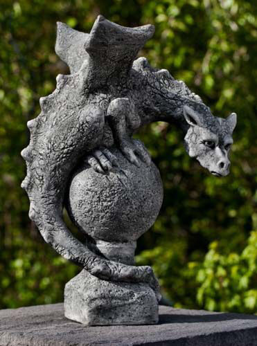 Garden statue of dragon sitting on a globe