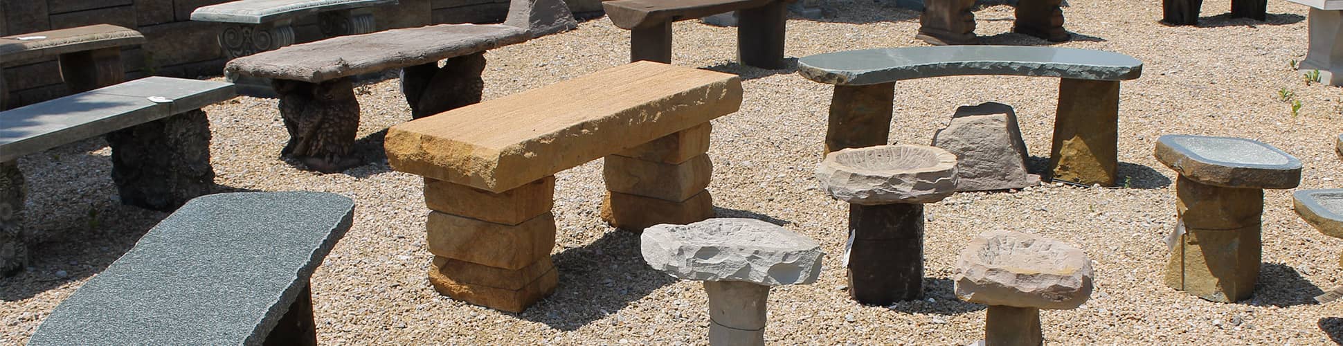 An arrangement of a selection of garden benches at Aquatic and Garden Decor in Cincinnati on a sunny day